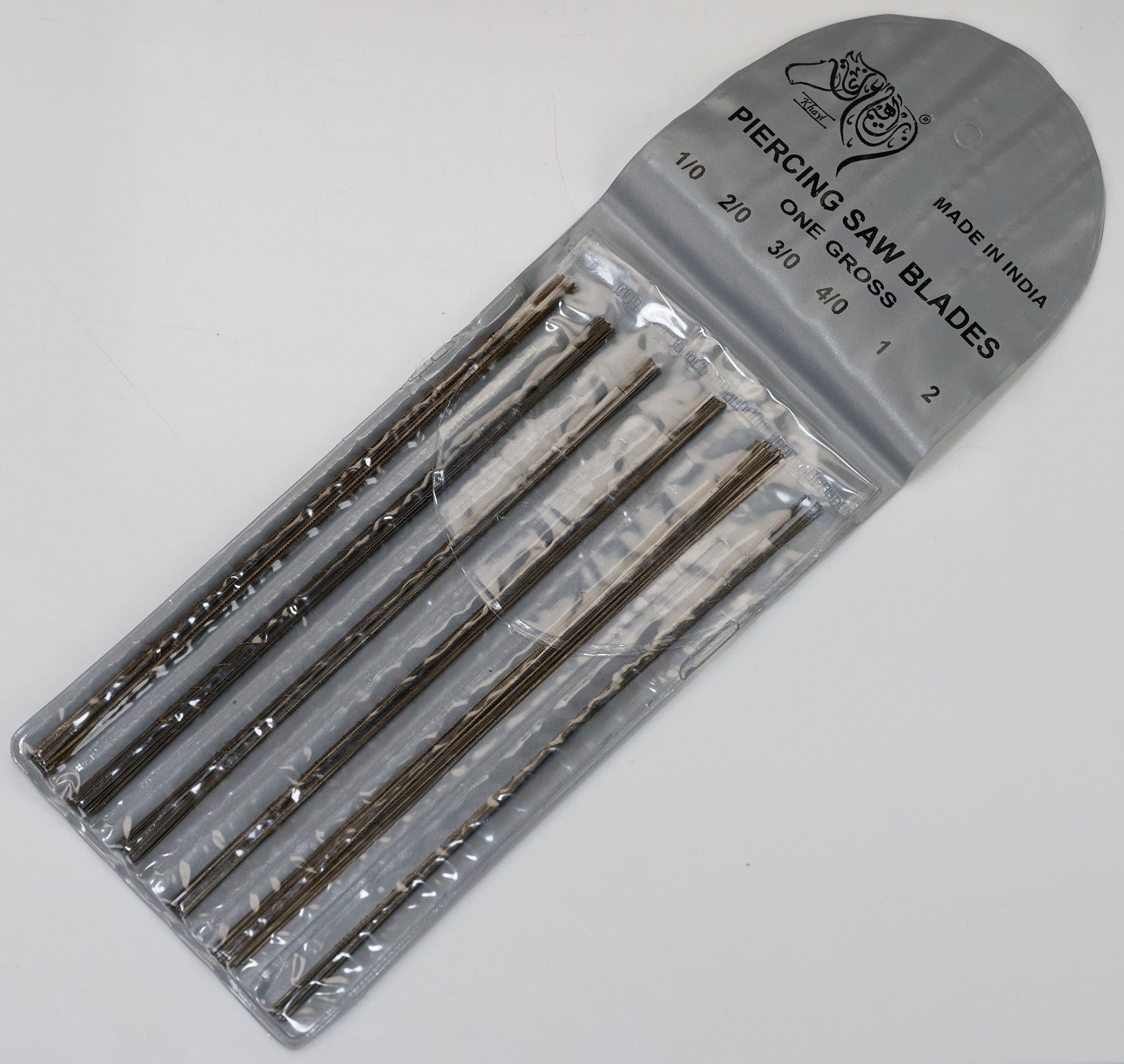 Assorted jewellers saw piercing blades in plastic holder with multiple grades